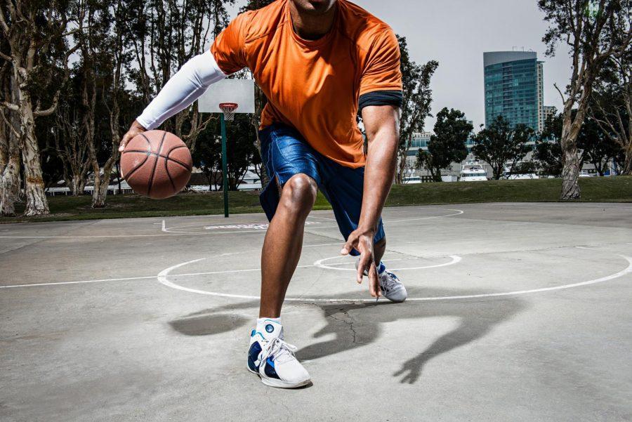Young man playing basketball on court, close up