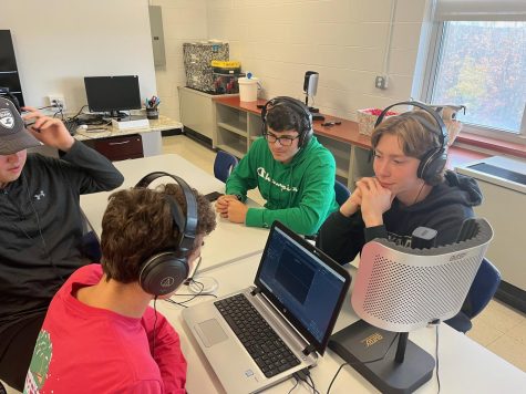 Lucas Parent (in red) talks about sports with fellow staffers Chris Cooke (in hat), Caden Watters (in green) and Will Denio.